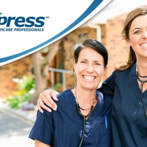 Two happy female caregivers in dark blue scrubs